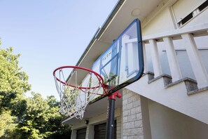 Ein Basketballkorb an einem Gebäude, mit einem Schild mit der Aufschrift 'TARMAK'.