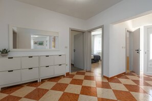 A hallway with a checkered floor, a white cabinet with drawers, and a mirror on the wall. - Villa Zelena Oaza (Labin)