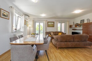 A modern living room with a dining table, sofas, and a TV. - Villa Zelena Oaza (Labin)