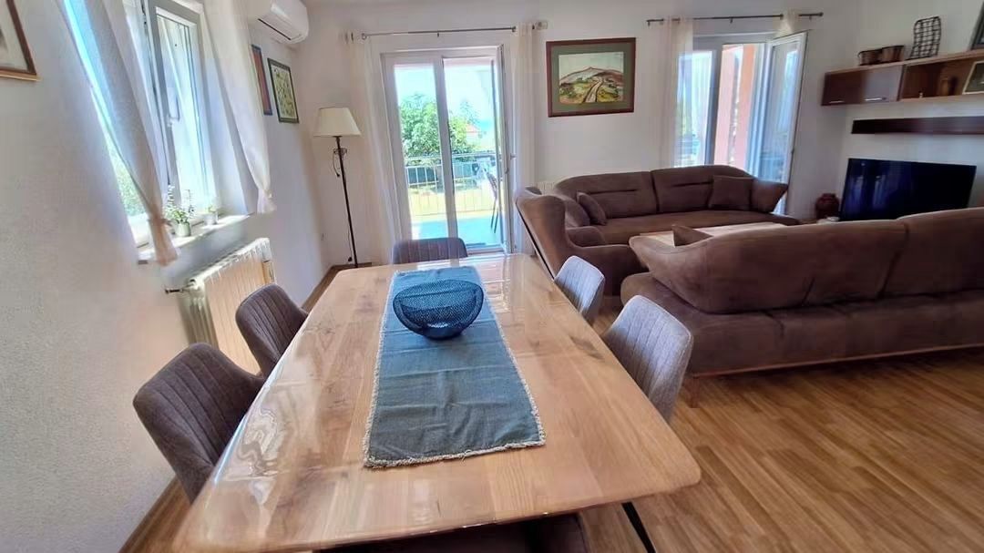 Un coin repas avec une table et des chaises en bois, un canapé et un téléviseur.