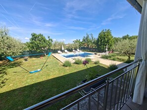 A backyard with a swimming pool, a swing, and a grassy area. - Villa Zelena Oaza (Labin)