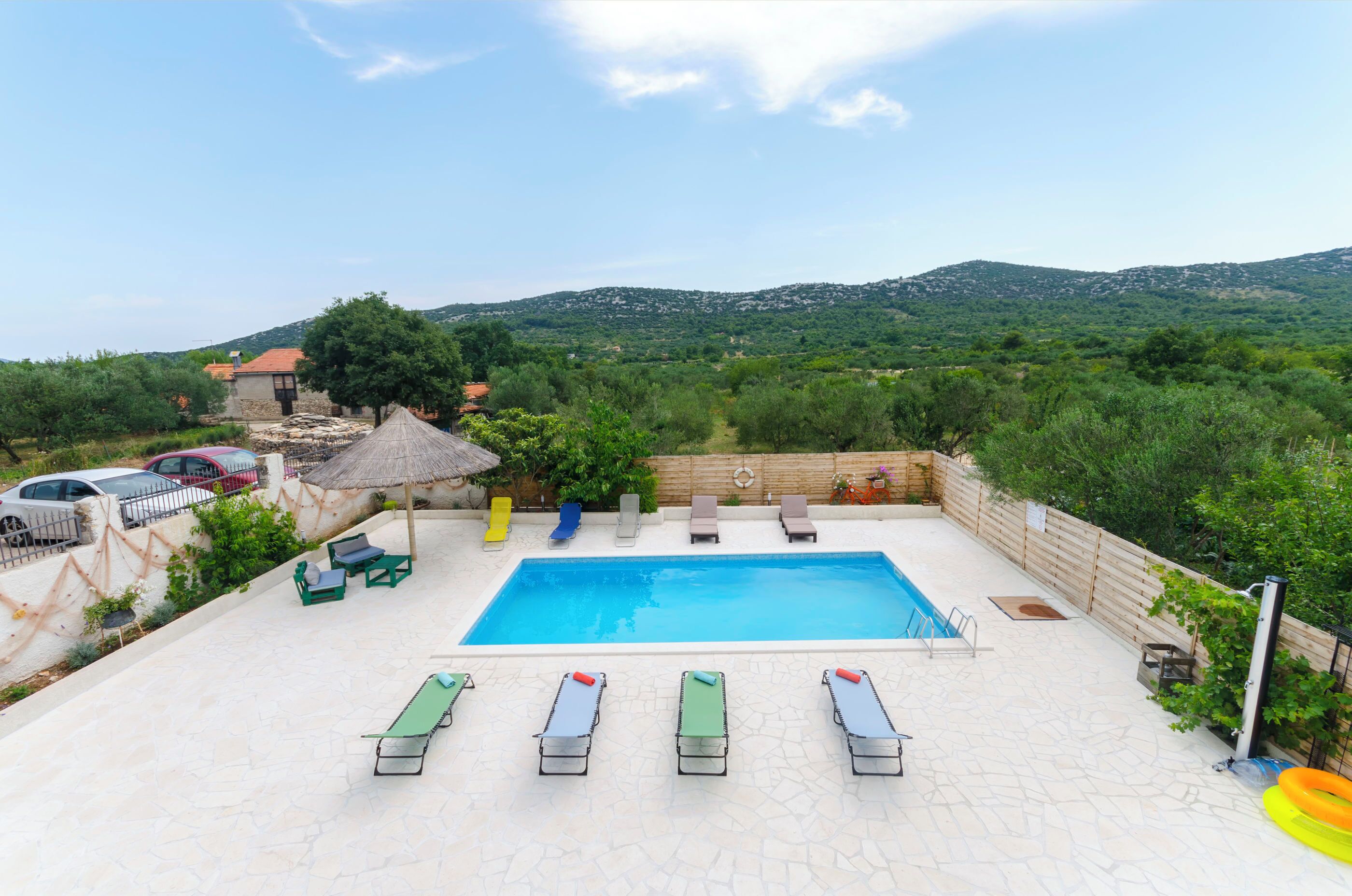 Una piscina amb gandules i vista a les colines.