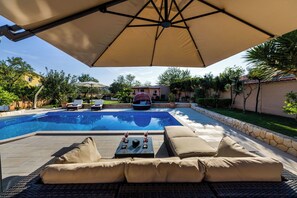 Piscine extérieure, piscine chauffée, parasols de plage, chaises longues