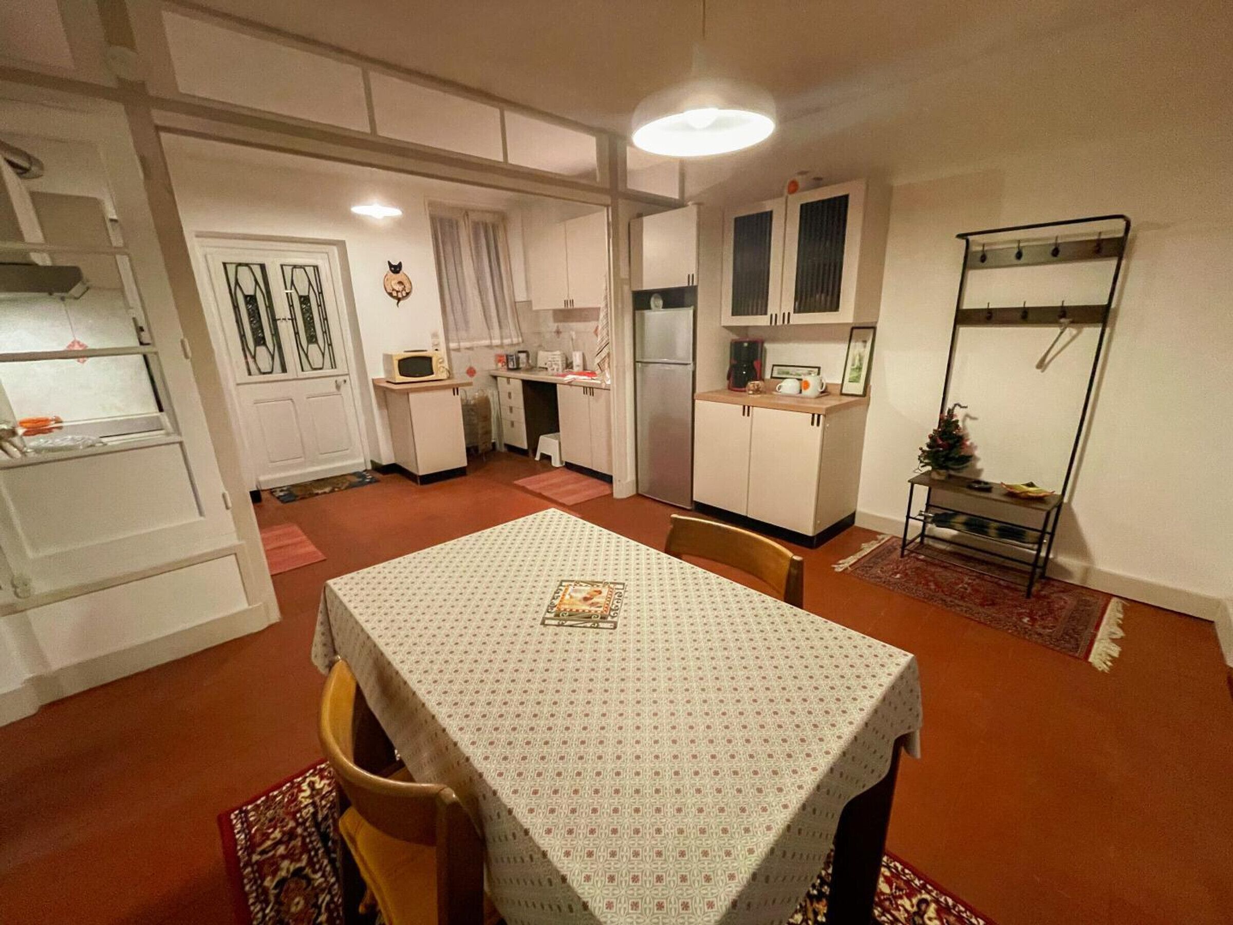 Une cuisine compacte comprenant une table à manger, des chaises et un petit réfrigérateur.