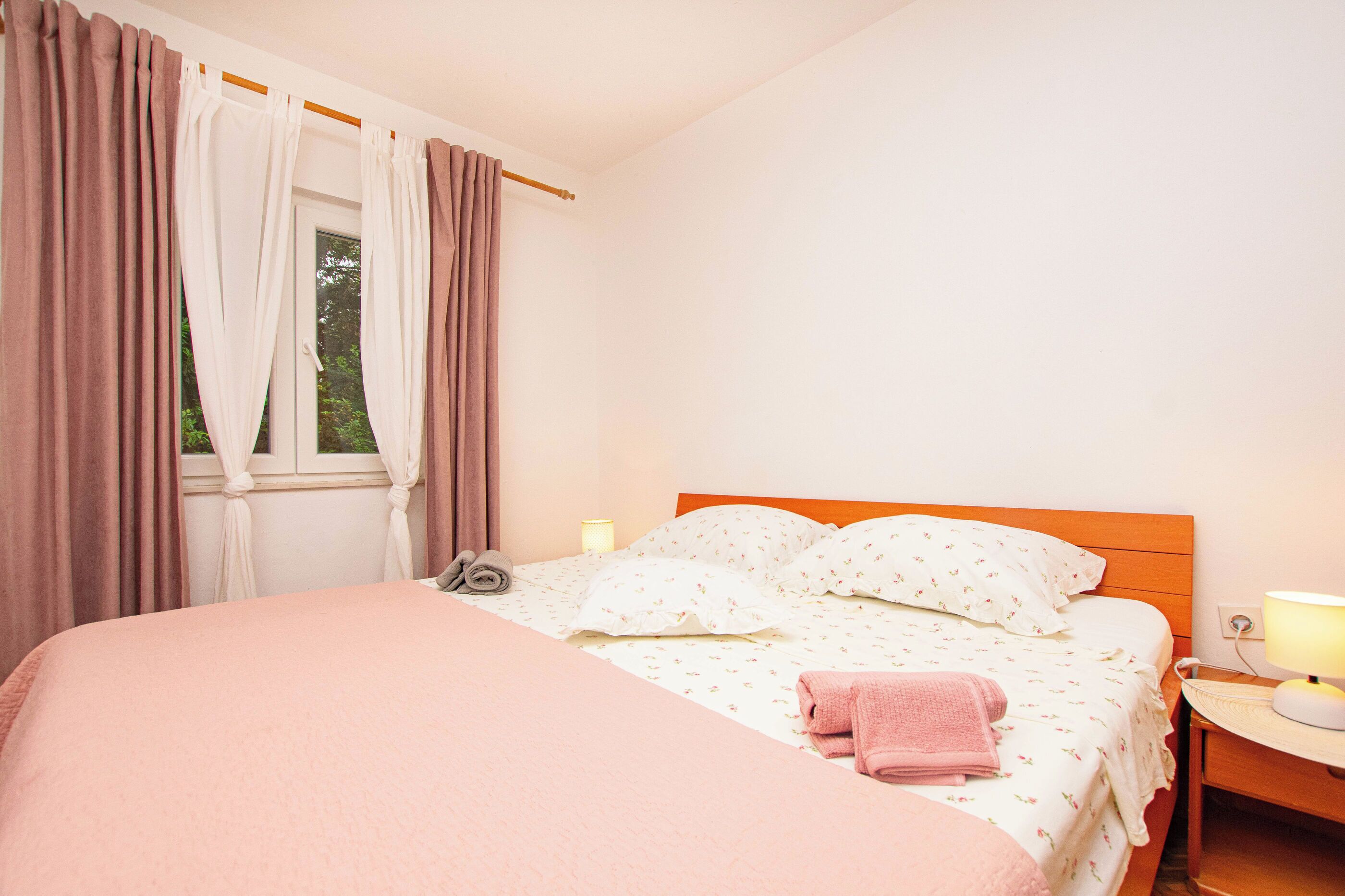 Une chambre à coucher avec un lit, des rideaux, une lampe de chevet et une table de chevet.