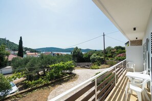 Ein Balkon mit Blick auf ein Weinberg, einen Steinweg und eine in der Ferne liegende Stadt.
