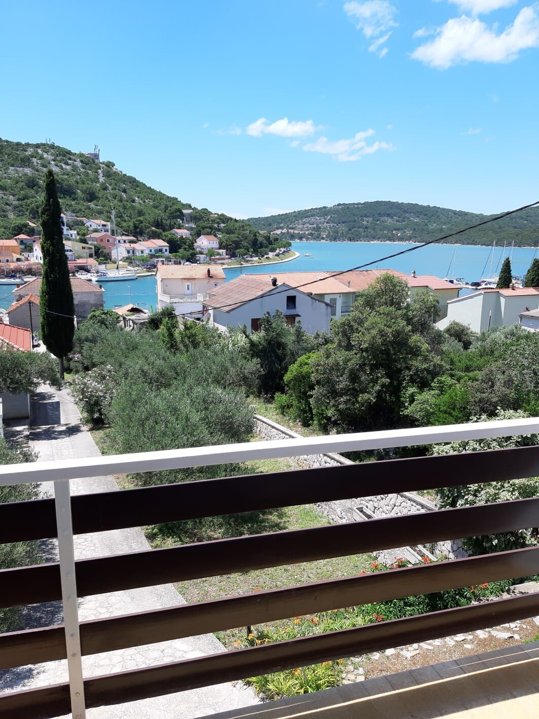 A coastal town with houses, a marina, and a clear view of the sea.