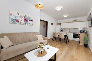 A modern apartment with a living room, kitchenette, and dining area. - Apartments and Room Kate (Tisno)