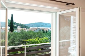 Ein Balkon mit Blick auf eine Hügelkette und ein Gewässer.