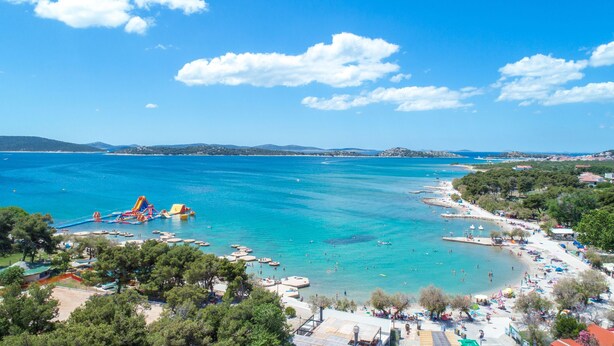 A coastal area with clear blue waters, a beach, and a water park. - Apartment Danka (Vodice)