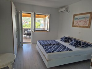 Une chambre à coucher avec un lit, une petite table et une fenêtre donnant sur l’extérieur.