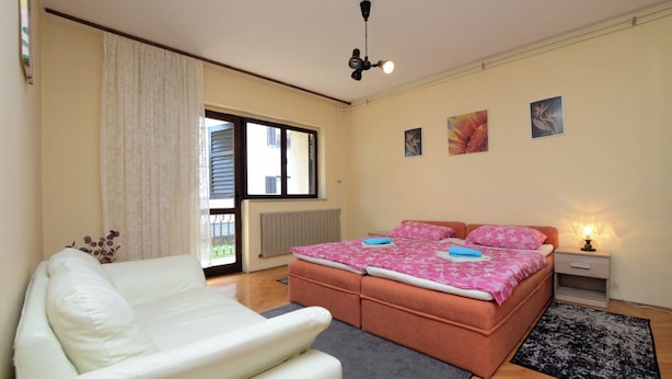 Ein Schlafzimmer mit Bett, Sofa, Nachttisch und Deckenventilator.