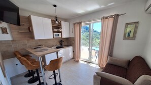 Una cocina moderna con comedor, sofá y vistas a un balcón.
