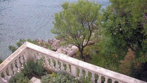 A view of a body of water with trees and a stone balustrade. - Apartment Orlic (Senj)