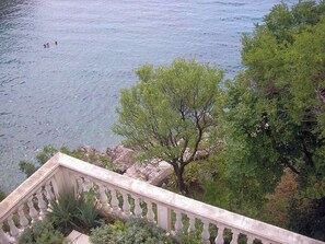 Blick auf ein Gewässer mit Bäumen und einer Steinbalustrade.