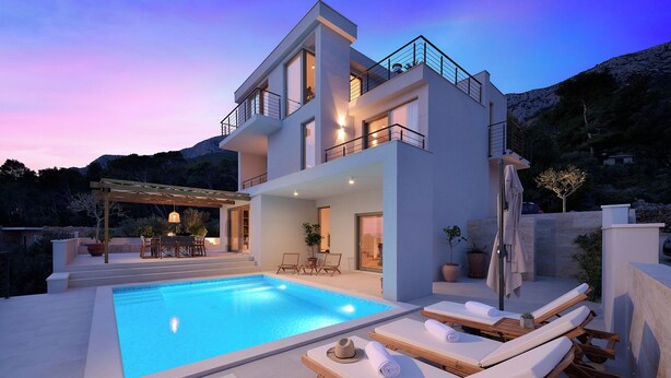 A modern two-story house with a swimming pool, lounge chairs, and a patio area. - Villa Bianka (Hvar)