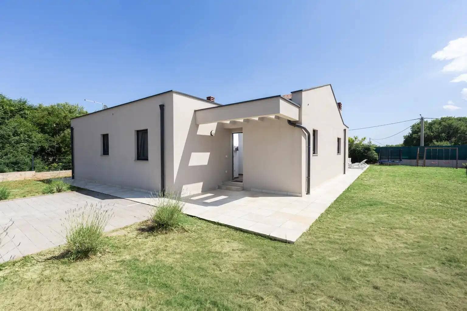 A modern two-story house with a covered patio area.