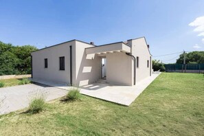 A modern two-story house with a covered patio area. - Villa Deluxe (Rasa)