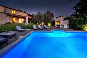 A swimming pool with lounge chairs and a fire pit area. - Villa Nina (Porec)