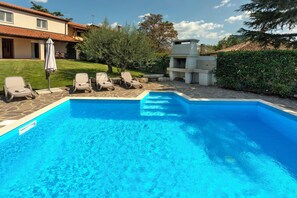 A swimming pool with lounge chairs, a barbecue area, and a well-maintained lawn. - Villa Nina (Porec)