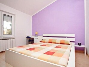 A bedroom with a bed, a window, a desk, and a nightstand. - Villa Nina (Porec)