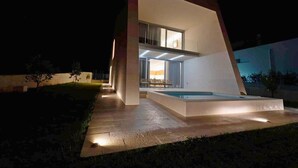 A modern house with a swimming pool, large windows, and a well-lit exterior at night. - Villa Aprilia (Zadar)