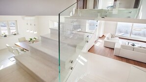 A modern interior with a staircase, a dining area, and a living space. - Villa Royal Blue (Rasa)
