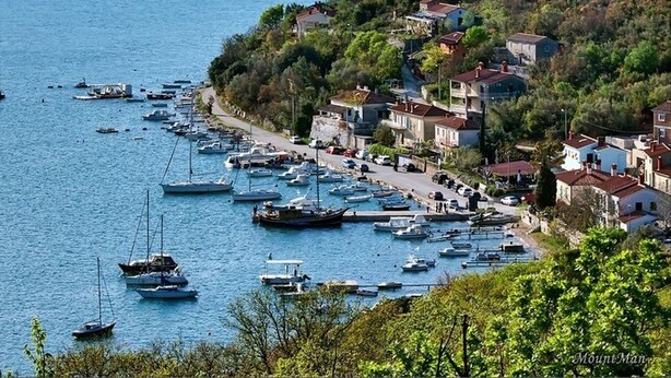 A coastal town with a marina filled with boats, surrounded by houses and greenery. - Villa Royal Blue (Rasa)