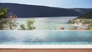 A swimming pool with a view of a lake and distant mountains. - Villa Royal Blue (Rasa)