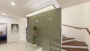 A modern interior with a glass partition, a staircase with wooden steps, and a potted plant. - Villa Vera (Novigrad)