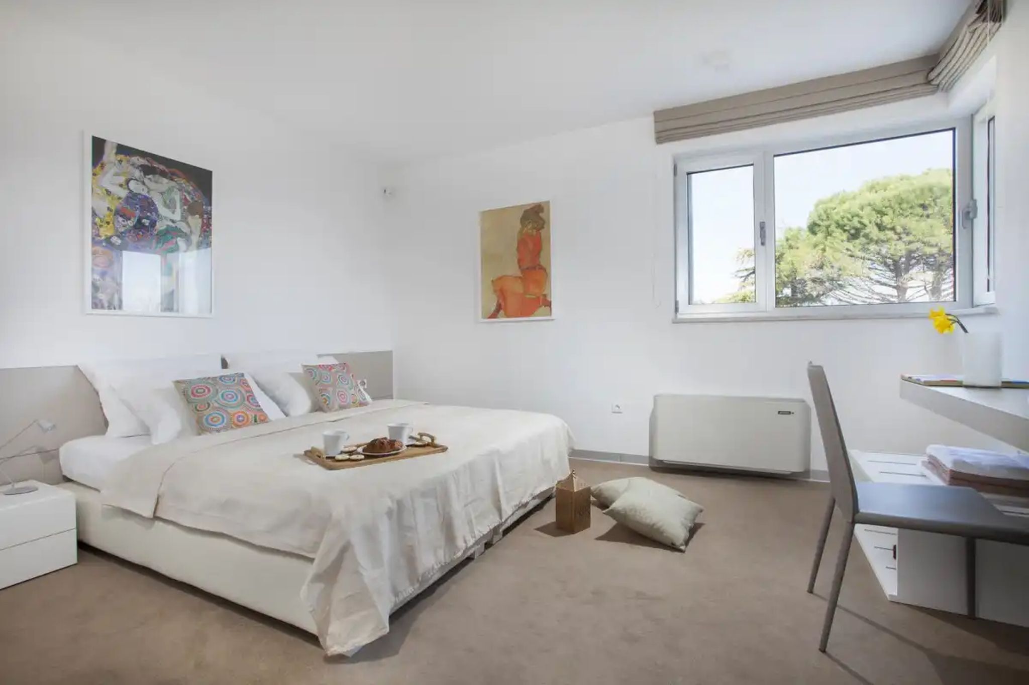 Un dormitorio con cama, escritorio y ventana.