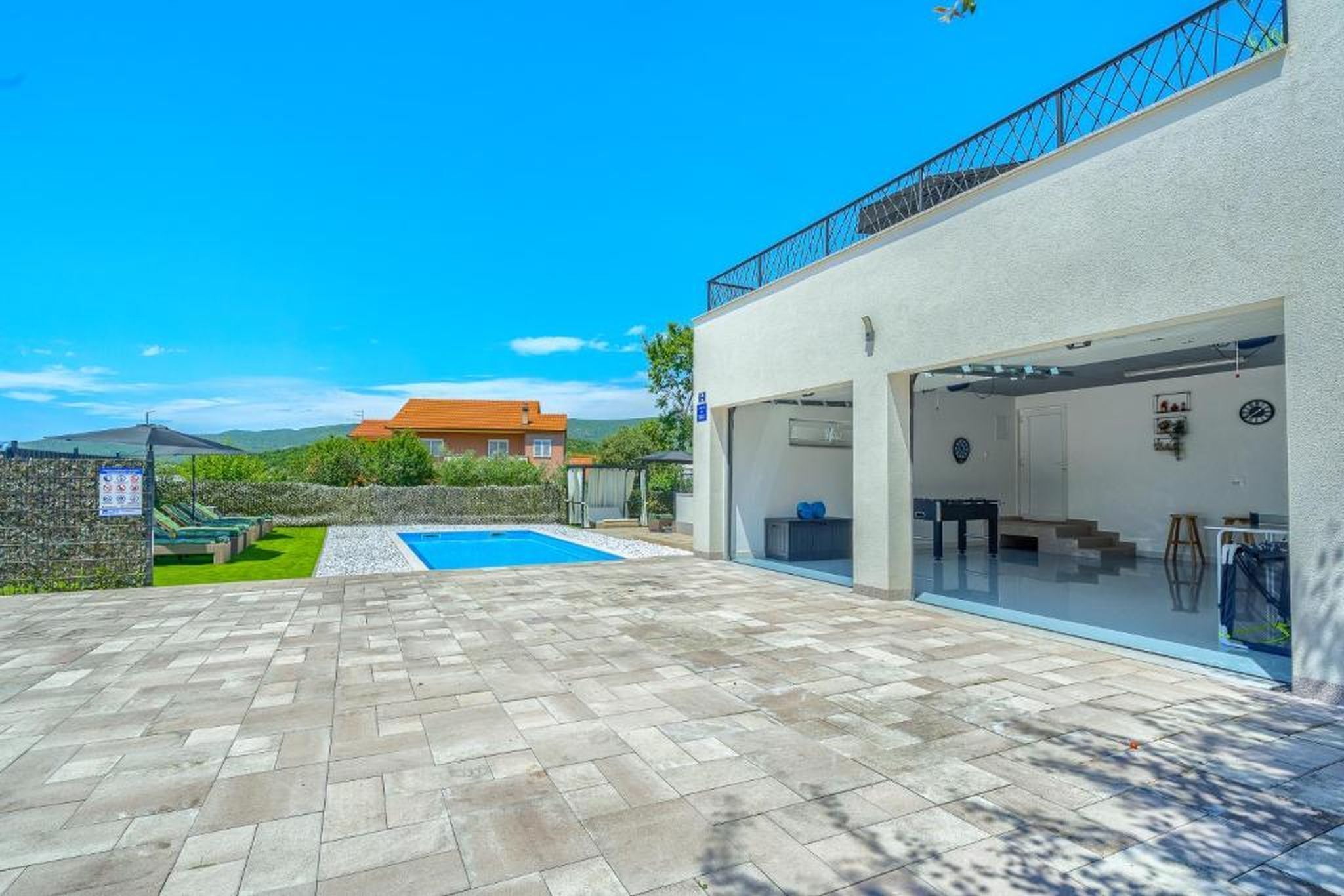 Une maison moderne dotée d’une piscine, d’un espace extérieur couvert et offrant une vue sur une montagne.