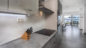 A modern kitchen with a built-in stove, a knife block, and a view to the outdoor area. - Villa Eva (Crikvenica)
