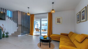Una sala de estar moderna con un sofá, una mesa de centro y una escalera.