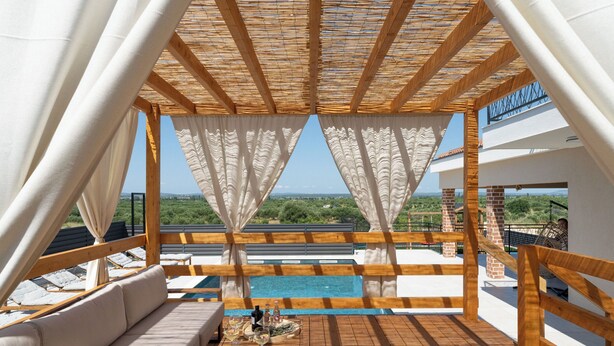 A wooden deck with a pool, white curtains, and a view of the landscape. - Villa A Lauda (Pakostane)