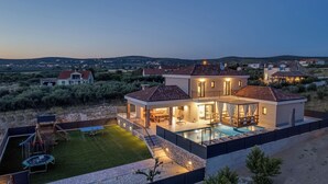 A modern house with a swimming pool, a covered patio, and a well-maintained lawn. - Villa A Lauda (Pakostane)