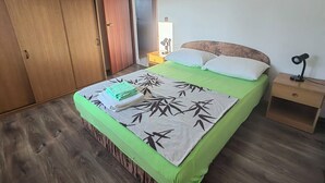 Una camera da letto con un letto, un comodino, un armadio e una porta che dà su un'altra stanza.