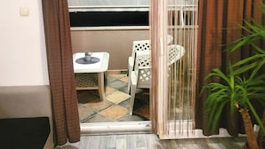 A room with a sliding glass door leading to an outdoor area with a table and chairs. - Apartments Mirko i Jela (Nin)