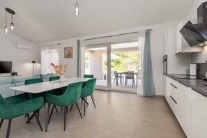 Een moderne keuken met een eethoek, een televisie en uitzicht.