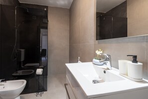 A modern bathroom with a large sink, a mirror, and a shower area. - Villa Tersaz (Sveta Nedelja)