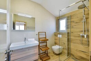 A modern bathroom with a wooden shower enclosure, a large mirror, and a wooden shelf unit. - Villa St Vid 4 (Privlaka)