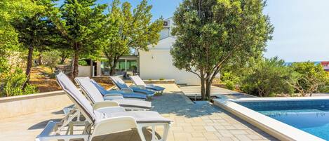 A poolside area with lounge chairs and a swimming pool.