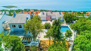 A residential area with a swimming pool, multiple houses, and a view of the sea. - Villa Turquoise Breeze (Novi Vinodolski)