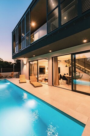A modern two-story house with a swimming pool, outdoor seating, and a dining area. - Villa Chic (Vodice)