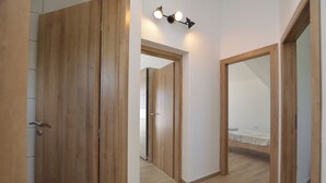 A hallway with wooden doors and a bed in the background. - Villa Maluma (Medulin)