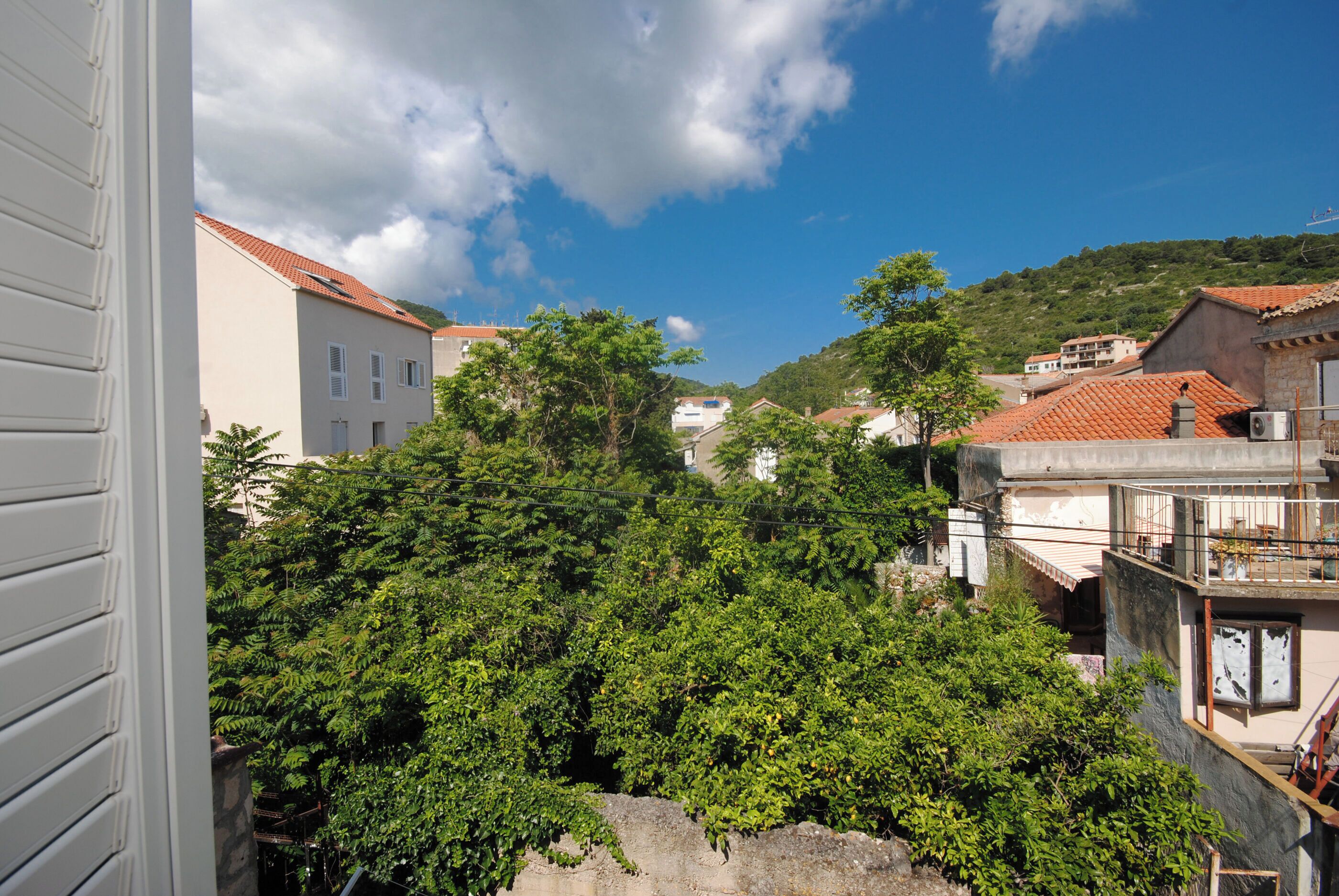 A courtyard with buildings, trees, and a clear sky.