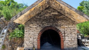 Una construcción de piedra con un arco de ladrillo, una escalera y un pozo para fuego.