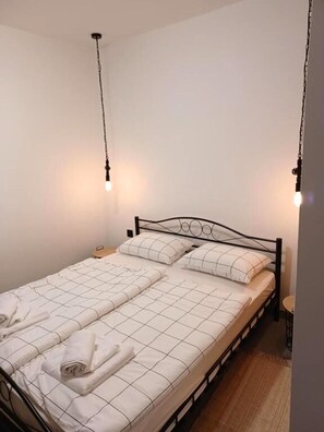 A single bed with a metal frame, white bedding, and two bedside tables. - Apartment Snjezana (Senj)
