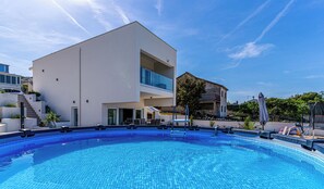 A modern building with a pool, a staircase, and a balcony. - Villa Raslina Sea View (Sibenik)