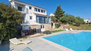 A two-story house with a swimming pool, outdoor seating, and a stone wall. - Villa Dream Come True (Jelsa)